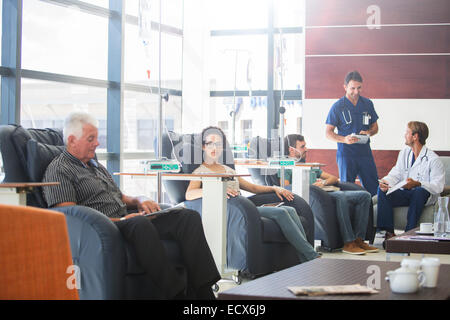 Patients undergoing medical treatment with doctors discussing in outpatient clinic Stock Photo