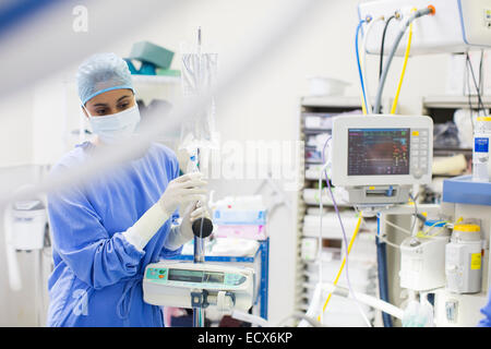 Nurse standing by medical and monitoring equipment Stock Photo