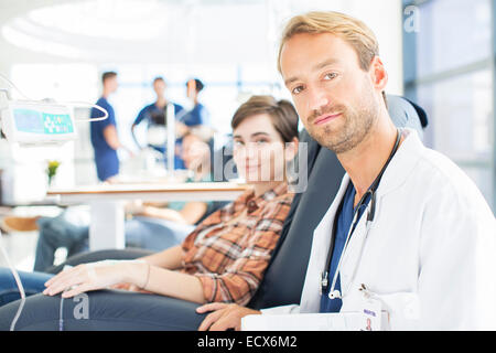 Portrait of doctor and patient undergoing medical treatment in outpatient clinic Stock Photo