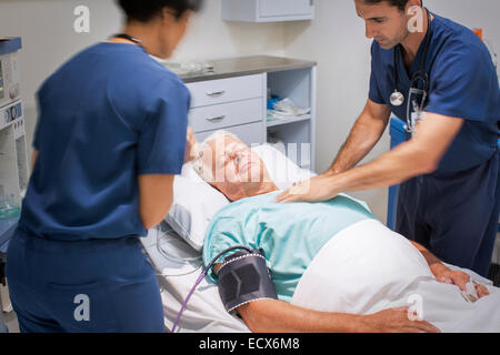 Doctor performing CPR on unconscious patient in emergency room Stock Photo