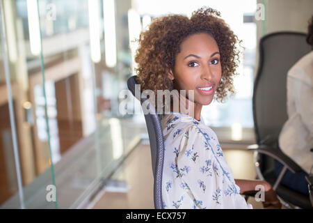 Portrait of young businesswoman sitting in chair and looking at camera Stock Photo