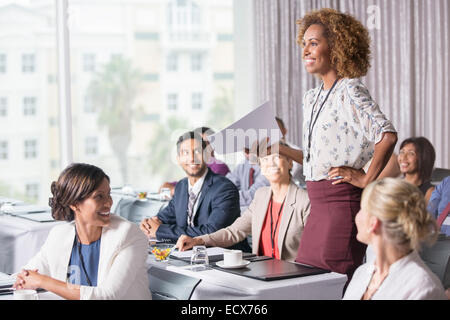 Businesswoman standing with document in hand during presentation in conference room Stock Photo