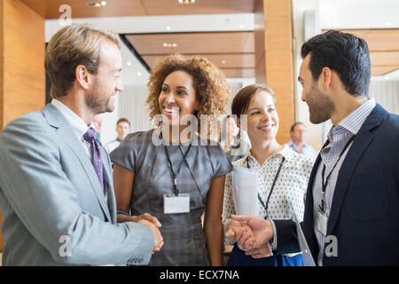 Four business people shaking hands at beginning of meeting Stock Photo