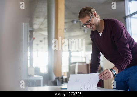 Businessman reading paperwork in office Stock Photo