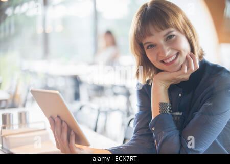 Businesswoman using digital tablet in cafeteria Stock Photo
