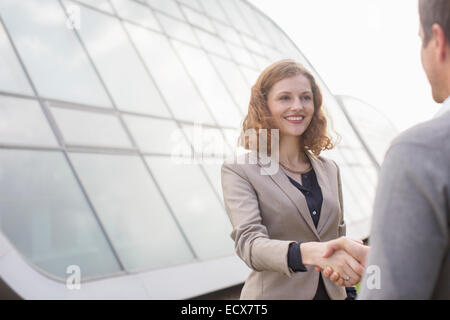 Business people shaking hands outdoors Stock Photo