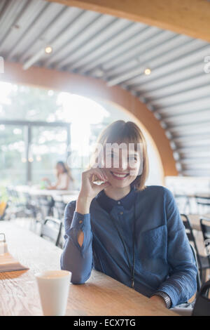 Businesswoman sitting at table in cafeteria Stock Photo