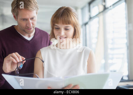 Business people reading paperwork in office Stock Photo