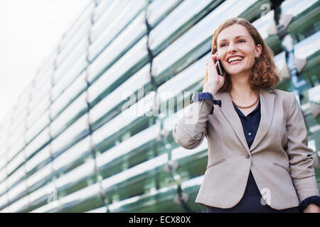 Businesswoman talking on cell phone outdoors Stock Photo