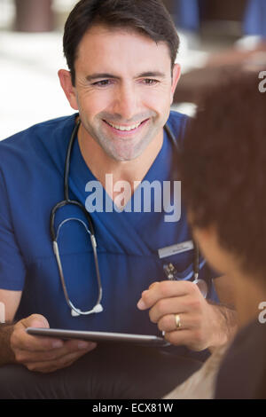 Portrait of smiling mid adult doctor holding tablet pc Stock Photo