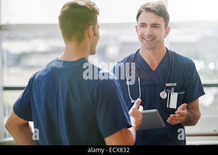 Two doctors talking, one holding tablet pc Stock Photo