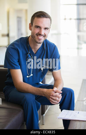 Portrait of male doctor sitting on sofa in hospital Stock Photo
