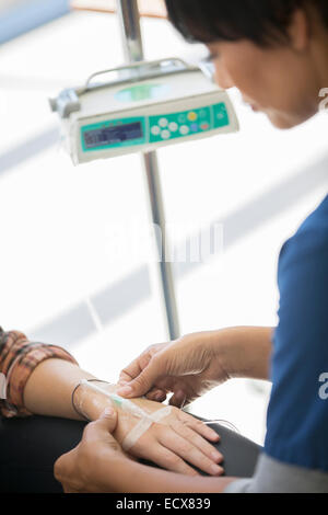 Doctor administering intravenous infusion to patient Stock Photo
