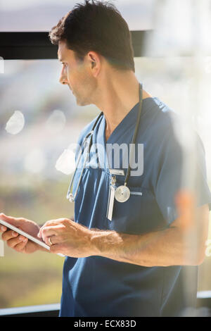 Middle Age Doctor Man Holding Anatomical Model Of Spinal Column 