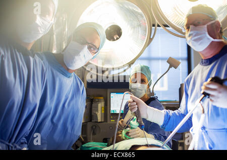 Team of doctors performing laparoscopic surgery in operating theater Stock Photo