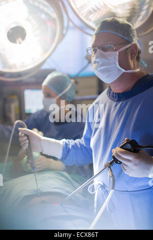 Surgeon performing laparoscopic surgery in operating theater Stock Photo