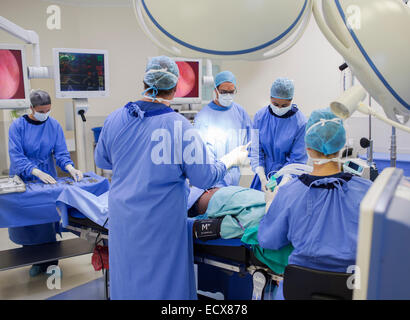 Team of doctors performing surgery in operating theater Stock Photo