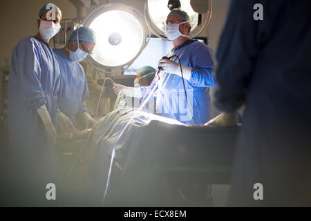 Team of doctors performing laparoscopic surgery in operating theater Stock Photo