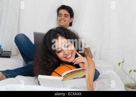 indian Beautiful Couple Sitting home reading book Stock Photo