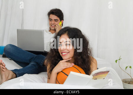 indian Beautiful Couple Sitting home reading book Stock Photo