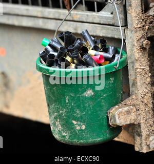empty shotgun cartridges in a bucket