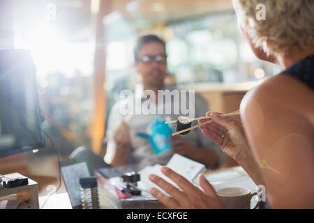 Business people eating sushi in office Stock Photo