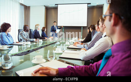 Businessman giving presentation to colleagues in conference room Stock Photo