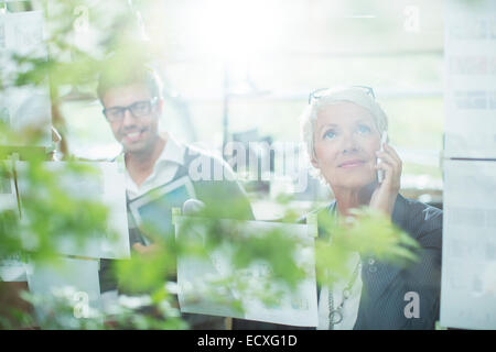 Businesswoman talking on cell phone in office Stock Photo