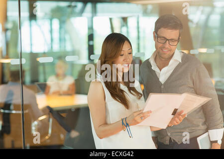 Business people reading paperwork in office Stock Photo