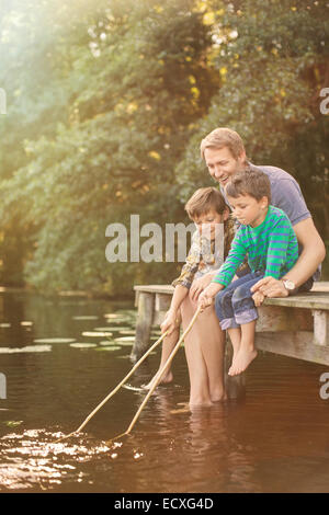 Father and sons fishing in lake Stock Photo