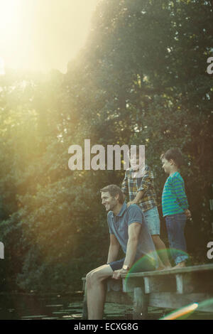 Father and sons relaxing at lake Stock Photo