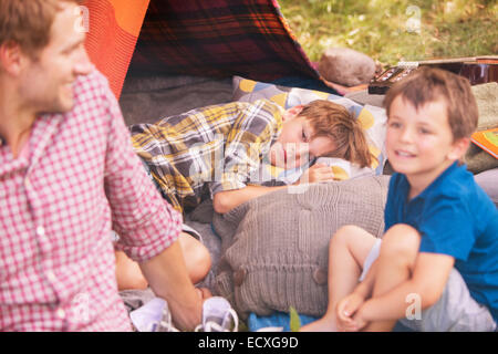 Father and sons smiling at camping tent Stock Photo