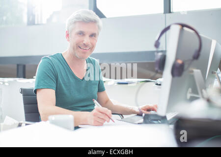 Older man working on computer at desk Stock Photo