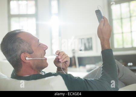 Close up of older man with earbuds talking on cell phone Stock Photo