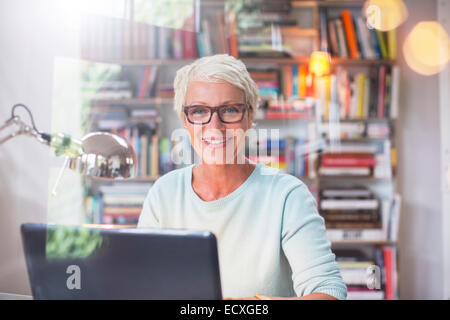 Businesswoman smiling at computer in home office Stock Photo