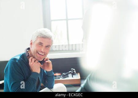 Older man listening to turntable with headphones Stock Photo