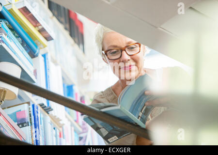 Low angle view of older woman reading book Stock Photo