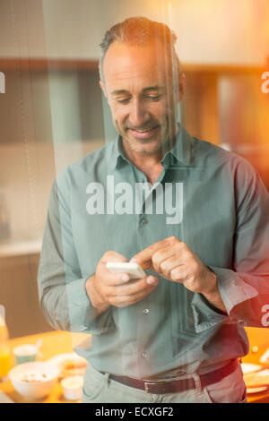 Older man texting on cell phone Stock Photo