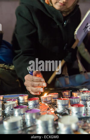 Trafalgar Square, London, UK. 21st Dec 2014. Members of the Pakistani community light candles in memory of those killed by the Taliban in the Peshawar school attack. Credit:  Matthew Chattle/Alamy Live News Stock Photo