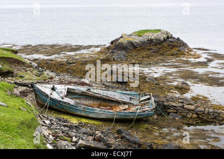 Weathered fishing boat lying on a rocky beach on the Isle of Lewis, Outer Hebrides, Scotland Stock Photo