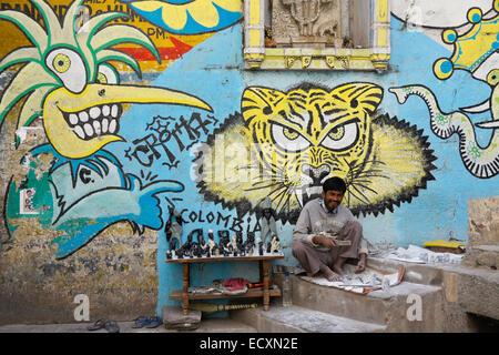 Stonecarver and graffiti art on wall of building, Udaipur, Rajasthan, India Stock Photo
