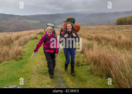 Two smiling female walkers on a track on the slopes of Moel Siabod in rainy weather, Capel Curig, Gwynedd, North Wales, UK Stock Photo