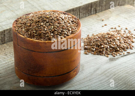 Flax seeds in bowl on wooden background Stock Photo