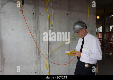 Investigative Engineering Services, Assistant Commissioner Tim Lynch inspects wiring on a new construction site in Manhattan, Ne Stock Photo