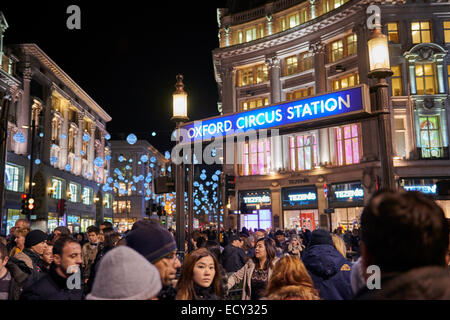 LONDON, UK - DECEMBER 20: Nighttime shot of very crowded Oxford Circus underground entrance with Christmas lights in the backgro Stock Photo