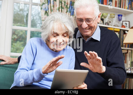 Senior Couple Using Digital Tablet For Video Call With Family Stock Photo