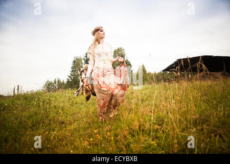 Caucasian woman walking in field Stock Photo