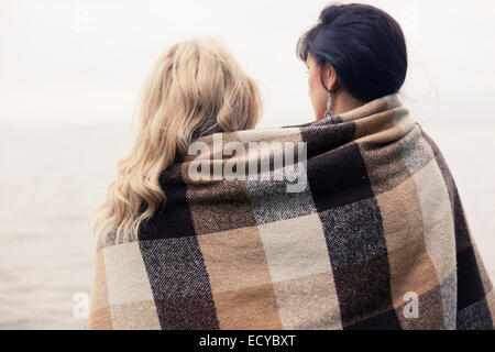 Caucasian women wrapped in blanket outdoors Stock Photo