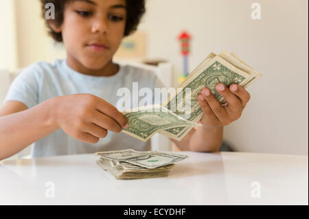 Mixed race boy counting money Stock Photo