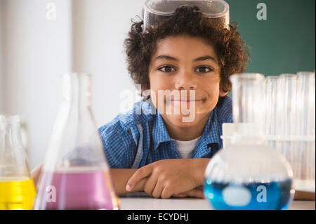 Mixed race boy sitting in classroom science lab Stock Photo